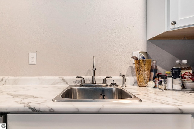 812 Forest Ave, Frankfort, MI 49635 - kitchen featuring sink, white cabinetry, and light stone countertops