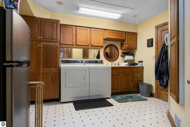 laundry area featuring washer and dryer and light tile floors