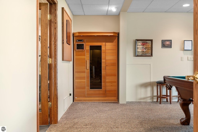 corridor with carpet flooring and a paneled ceiling