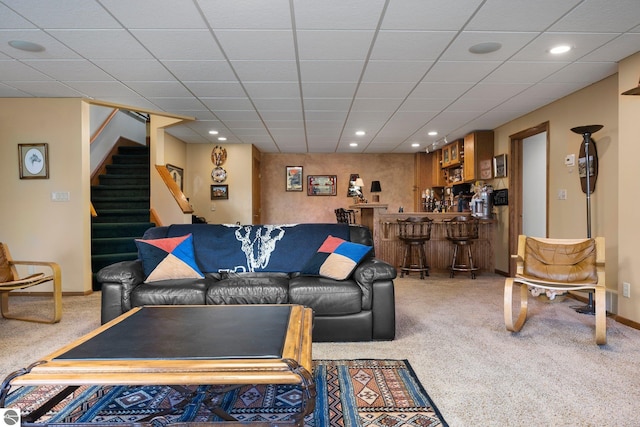 carpeted living room with bar area and a paneled ceiling