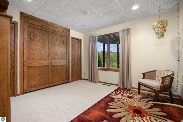 sitting room featuring a paneled ceiling and carpet