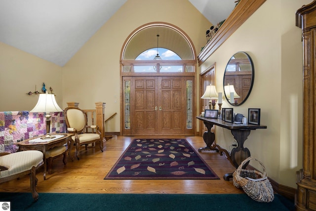 foyer with high vaulted ceiling and light wood-type flooring