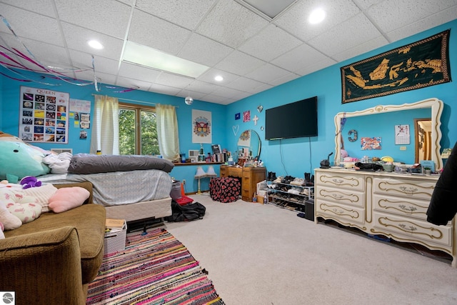 bedroom with carpet floors and a drop ceiling