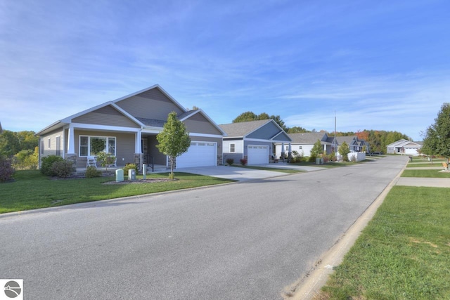 view of front of home featuring covered porch, a garage, and a front yard