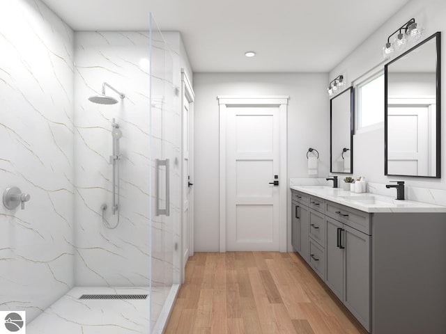 bathroom with a tile shower, vanity, and hardwood / wood-style flooring