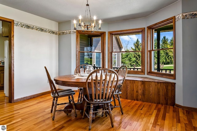 dining space featuring light hardwood / wood-style flooring and a chandelier