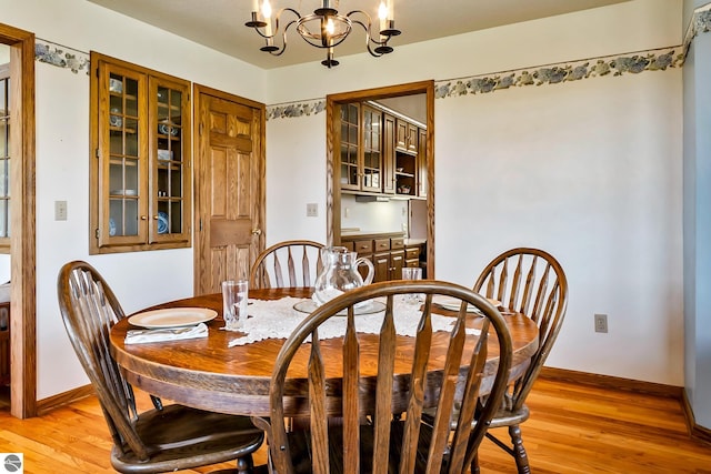 dining room with light hardwood / wood-style flooring and a chandelier