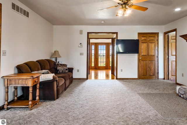 carpeted living room featuring ceiling fan