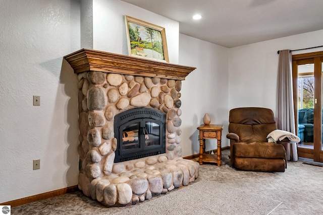 sitting room featuring carpet flooring and a stone fireplace