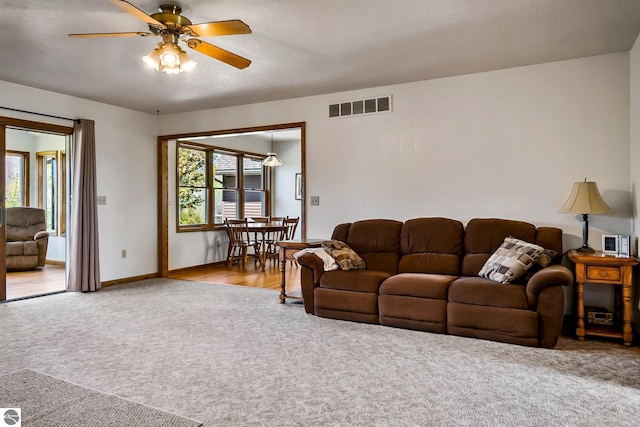 living room featuring ceiling fan and light colored carpet