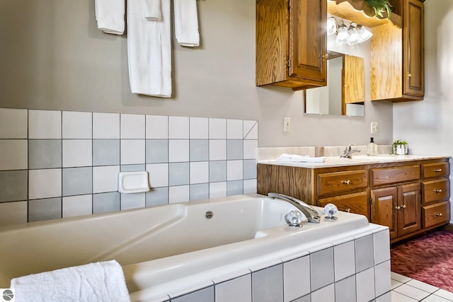 bathroom with tile patterned flooring, vanity, and tiled tub