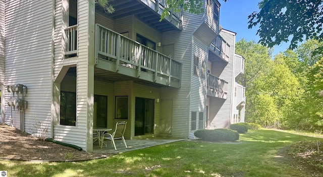 rear view of house featuring a lawn and a patio