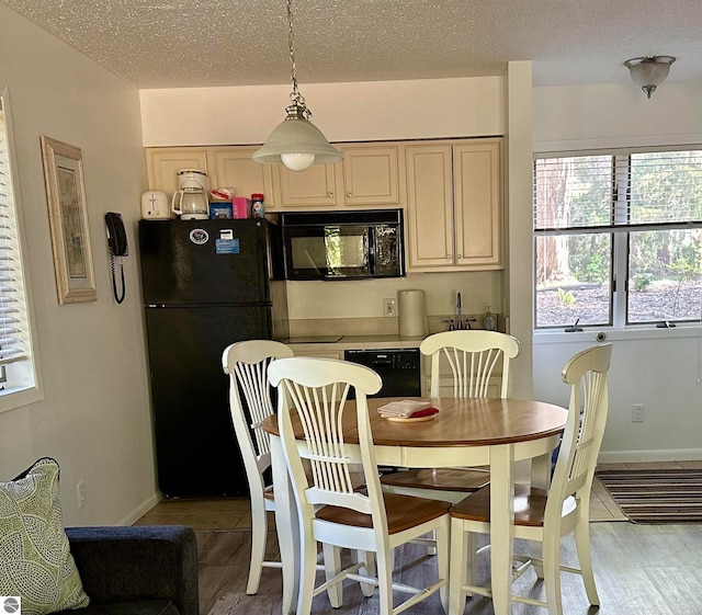 dining area featuring a textured ceiling, hardwood / wood-style floors, and a healthy amount of sunlight