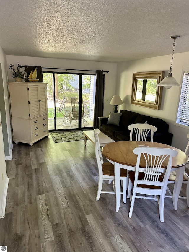 dining area featuring dark hardwood / wood-style flooring and a textured ceiling