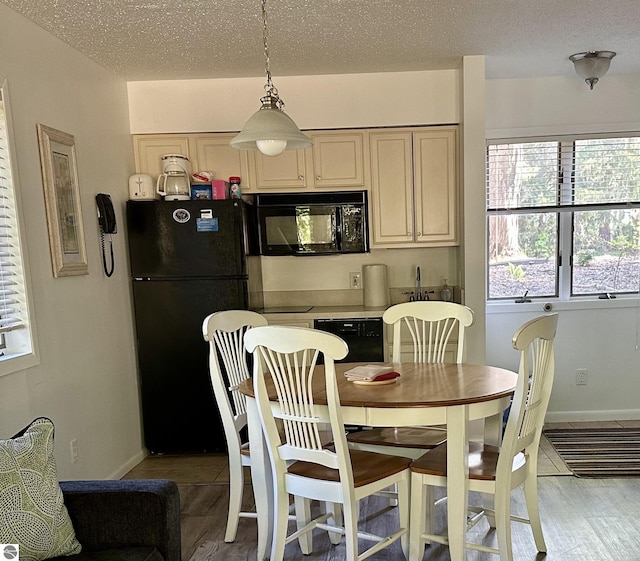 dining area with plenty of natural light, a textured ceiling, and hardwood / wood-style floors