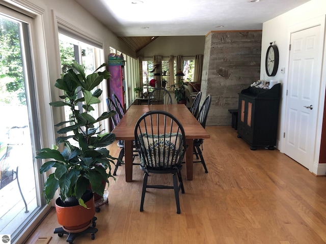 dining area featuring hardwood / wood-style flooring and vaulted ceiling