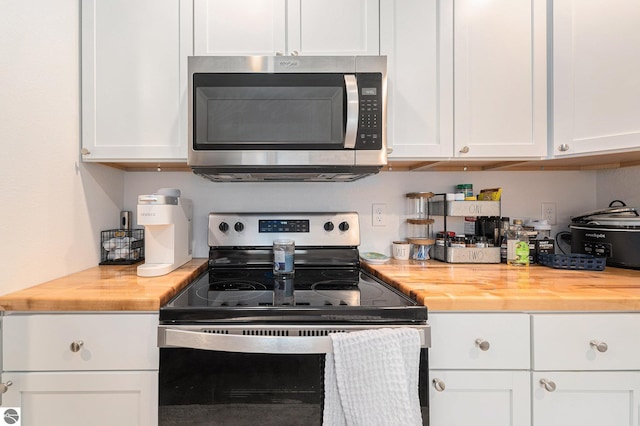 kitchen featuring stainless steel appliances, white cabinetry, and wood counters