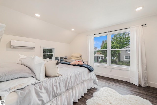 bedroom with a wall mounted AC, dark hardwood / wood-style flooring, and vaulted ceiling