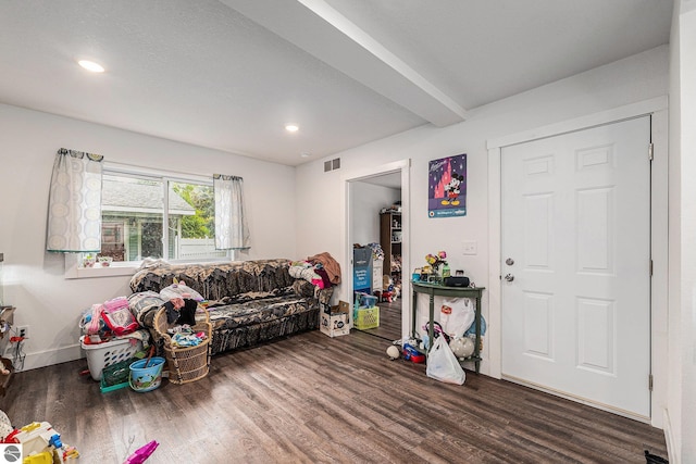 living room featuring beamed ceiling and dark hardwood / wood-style floors