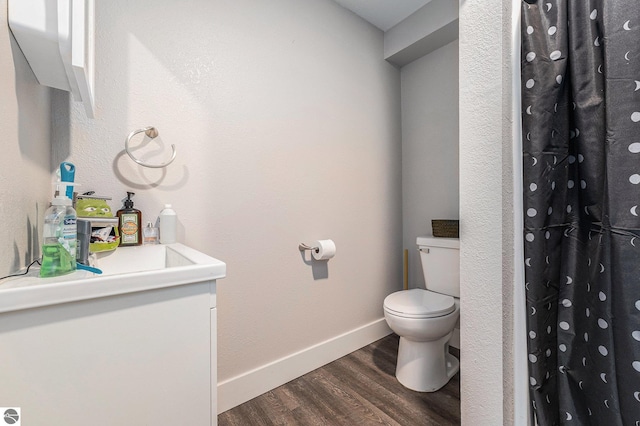 bathroom with toilet, hardwood / wood-style flooring, and a shower with curtain