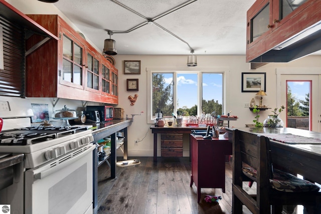 kitchen with a textured ceiling, pendant lighting, gas range gas stove, and dark hardwood / wood-style flooring