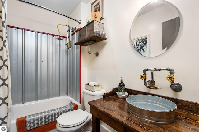 full bathroom featuring a textured ceiling, shower / bath combo, vanity, and toilet