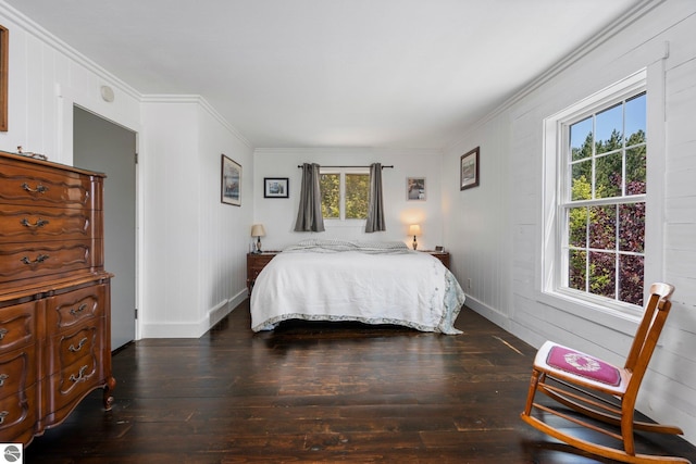 bedroom with ornamental molding and dark hardwood / wood-style flooring