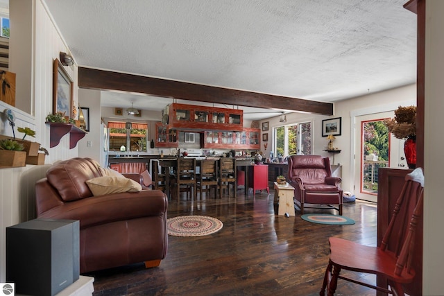 living room featuring beamed ceiling, a textured ceiling, and hardwood / wood-style flooring