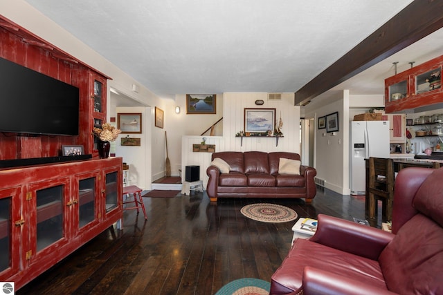 living room featuring beam ceiling and dark wood-type flooring