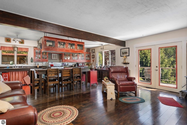 living room with a textured ceiling, beam ceiling, french doors, and hardwood / wood-style floors