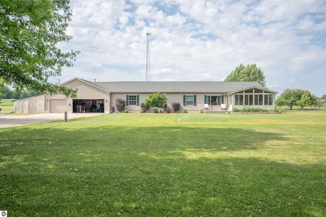 single story home featuring a sunroom, a front yard, and a garage