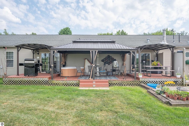 rear view of property featuring a lawn, a pergola, a wooden deck, and a hot tub