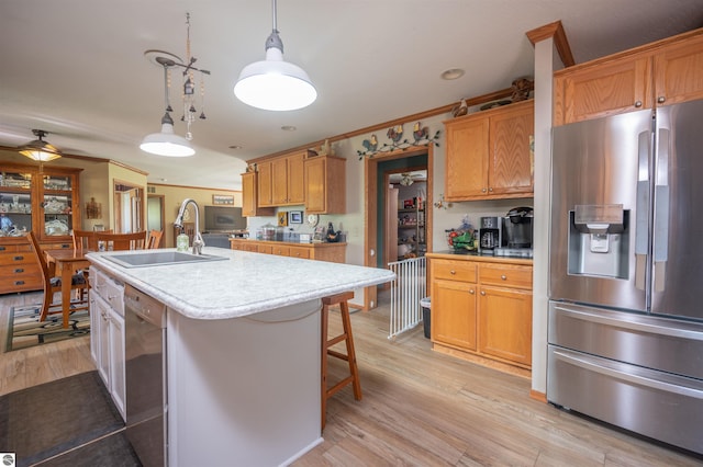 kitchen with stainless steel appliances, a kitchen island with sink, crown molding, sink, and hanging light fixtures