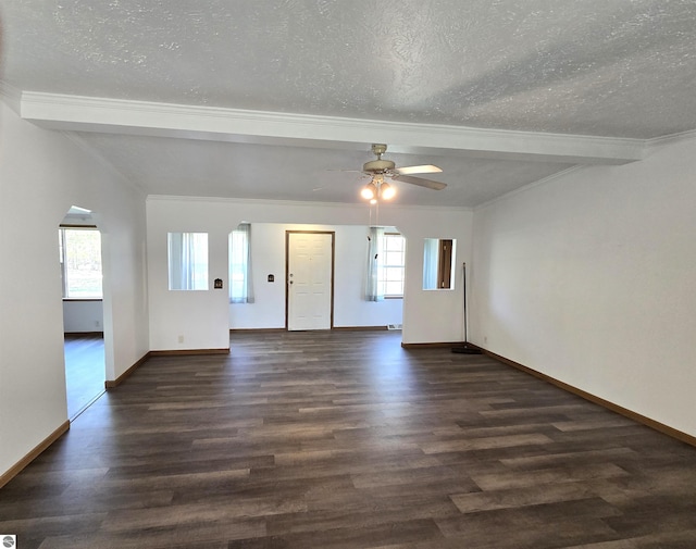 unfurnished room with beamed ceiling, a healthy amount of sunlight, and dark hardwood / wood-style floors