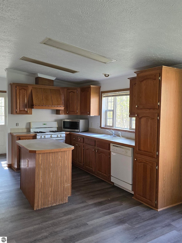 kitchen with white appliances, dark wood-type flooring, premium range hood, a textured ceiling, and a center island