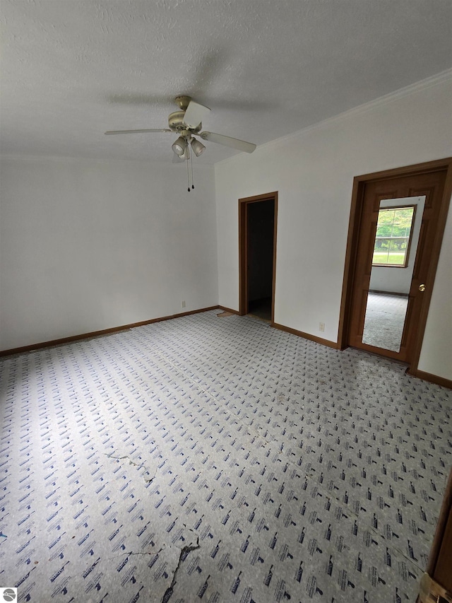 carpeted empty room with ceiling fan and a textured ceiling