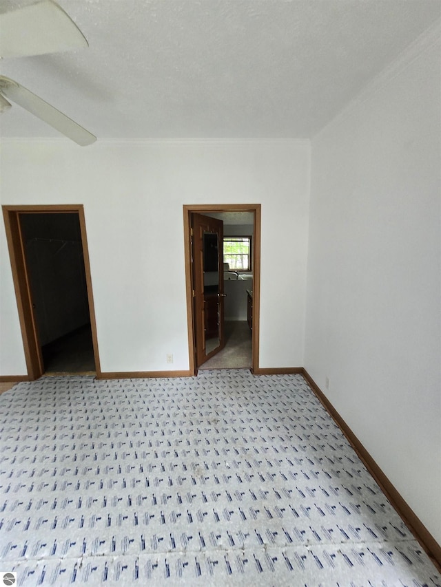 carpeted empty room with ceiling fan and a textured ceiling