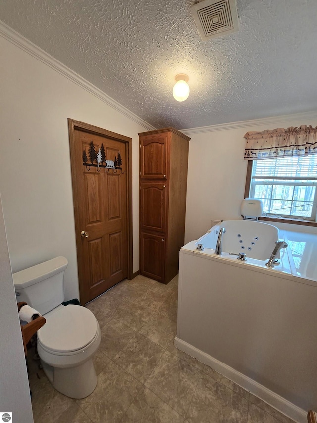 bathroom featuring crown molding, tile flooring, a textured ceiling, a washtub, and toilet