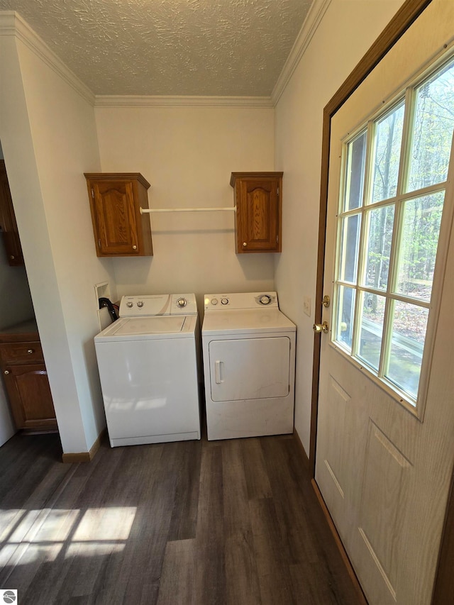 clothes washing area with cabinets, a wealth of natural light, dark hardwood / wood-style floors, and a textured ceiling