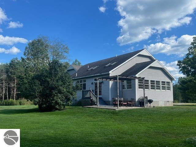 rear view of property featuring a pergola, a yard, and a patio