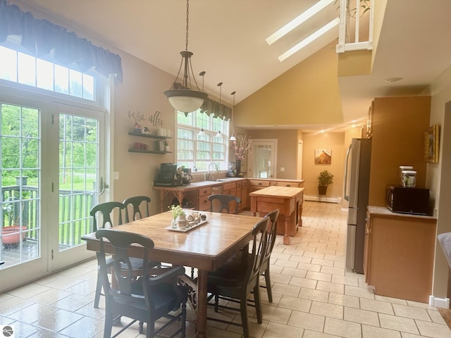 dining room with a skylight, high vaulted ceiling, a baseboard radiator, and sink