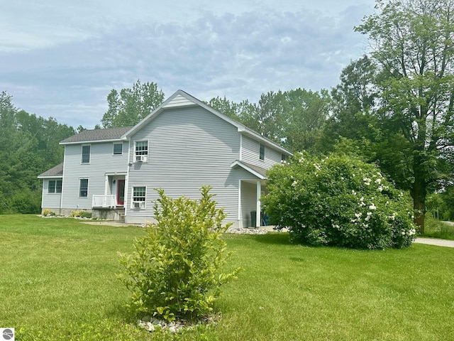 rear view of house featuring a yard