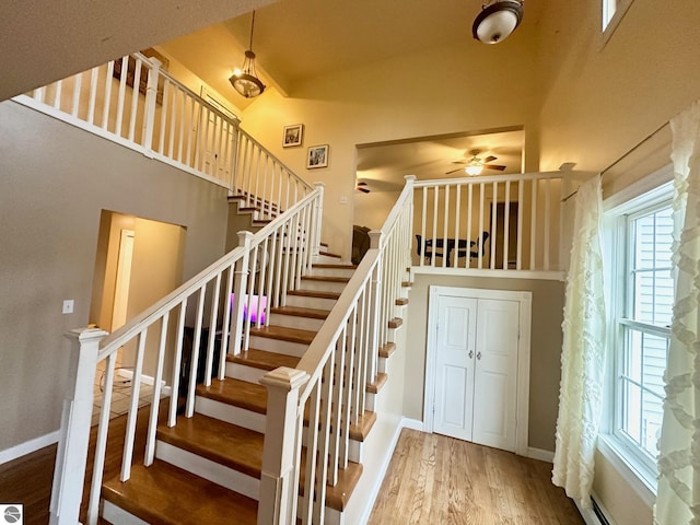 staircase with wood-type flooring, vaulted ceiling, plenty of natural light, and ceiling fan