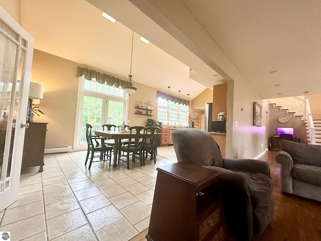 interior space featuring vaulted ceiling, light tile patterned floors, and a baseboard radiator