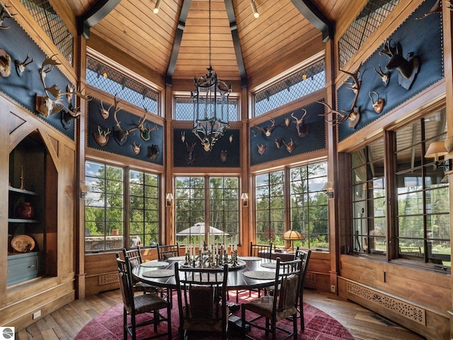 sunroom featuring a chandelier, plenty of natural light, and wooden ceiling