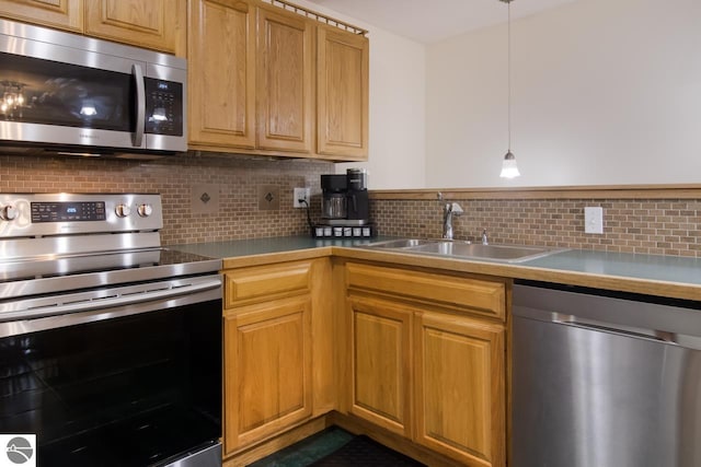 kitchen featuring backsplash, sink, decorative light fixtures, and appliances with stainless steel finishes