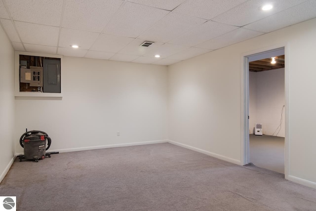 unfurnished room featuring carpet, a paneled ceiling, and electric panel