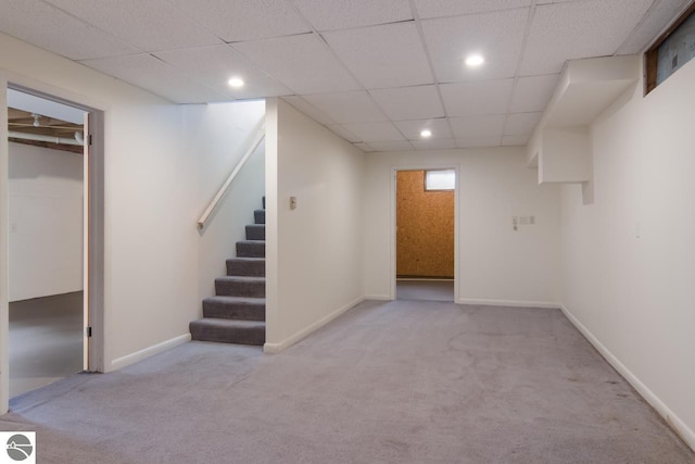 basement with light carpet and a drop ceiling