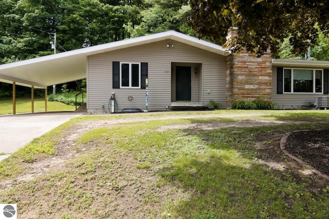 ranch-style house with a front yard and a carport