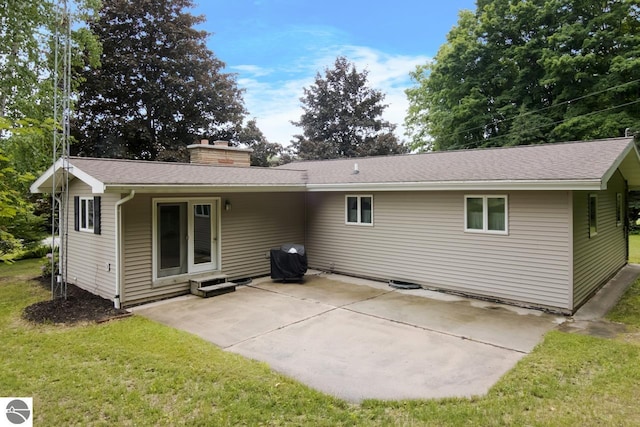 back of property featuring a lawn and a patio